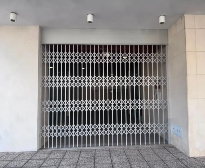 Expanding security grille at a commercial entrance
