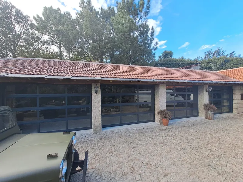 Glazed Full View sectional doors on a stone house
