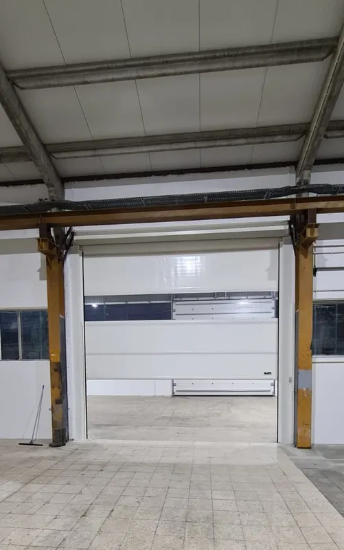 Open industrial sectional door in a warehouse