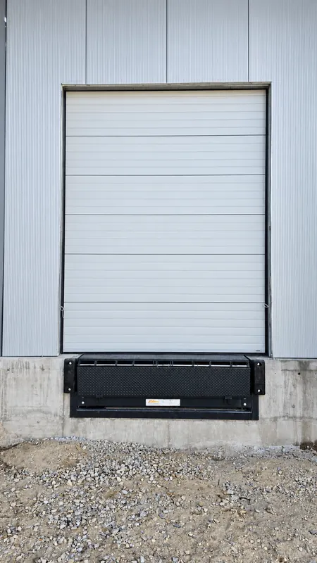 Industrial sectional door with dock leveller