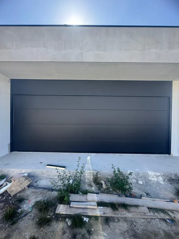 Black sectional door on a house under construction